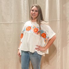 "Add a burst of color to your wardrobe with our Embroidered Flower Breezy Top. Featuring bright embroidered flowers on a white background, this poncho style top is perfect for any occasion. Embrace the playful and quirky side of fashion with this unique piece." Poncho Style Top, Burst Of Color, Poncho Style, Embroidered Flowers, Unique Pieces, White Background, Boutique, Wardrobe, Flowers