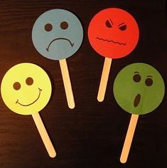 four lollipops with faces drawn on them