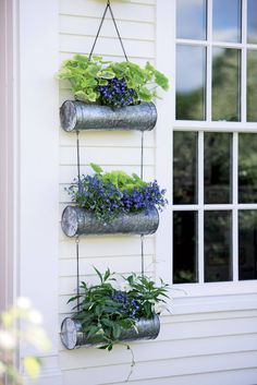 three metal planters hanging on the side of a house