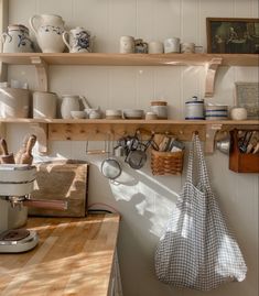 a kitchen with shelves filled with pots, pans and utensils on it