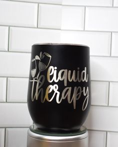 a wine glass that says equad therapy sitting on top of a metal container