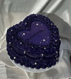 a purple heart shaped cake with white stars on it