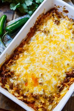 an enchilada casserole in a white dish on a wooden table