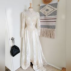 a dress on display in front of a wall hanging with a handbag and purse