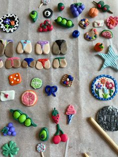 there are many different types of buttons on the table together, including brooches and pins