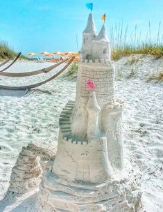 a sand castle sitting on top of a sandy beach