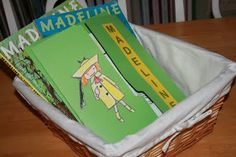 a basket filled with books sitting on top of a wooden table