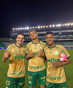 three soccer players pose for a photo on the field