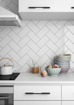 a kitchen counter with bowls and utensils on it, next to an oven