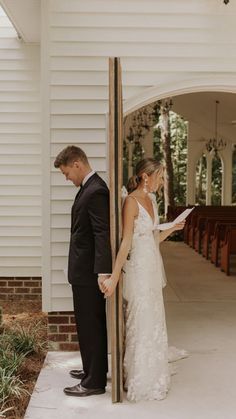 a bride and groom standing in front of the alter at their wedding ceremony, looking at each other