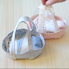 two small baskets are sitting on a table with cloths in them and one is holding a baby's diaper