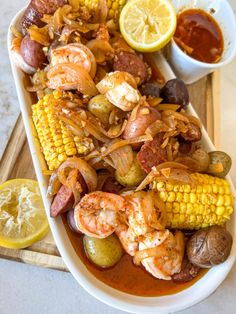 a platter filled with shrimp, corn and potatoes