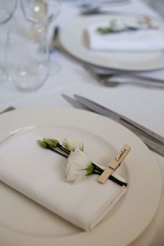 a white plate topped with flowers on top of a table next to utensils