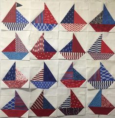 several red, white and blue quilts are arranged in the shape of sailboats