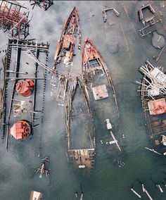 an aerial view of several boats docked in the water near one another and surrounded by scaffolding