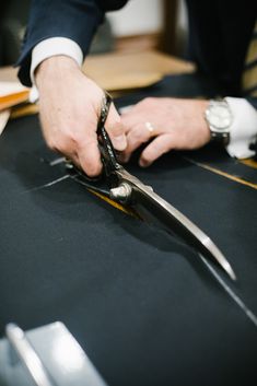 a person cutting something with scissors on a table