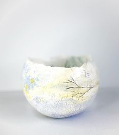 a white bowl with trees painted on it