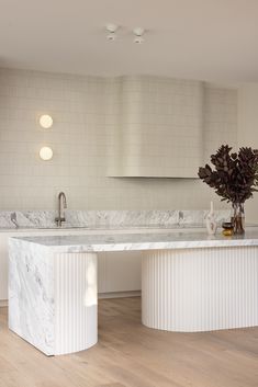 a kitchen with marble counter tops and white cabinets, along with an island in the middle