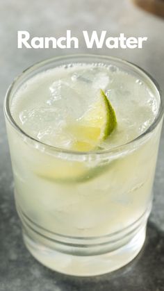 a close up of a drink in a glass with a lime slice on the rim