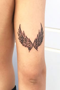 a close up of a person's legs with tattoos on their thighs and wings