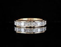 two gold wedding bands with princess cut diamonds on each band, set against a black background