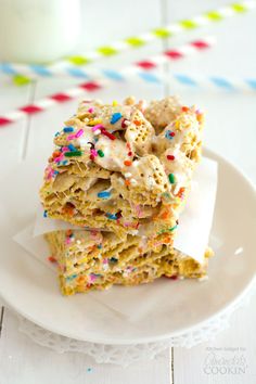 three pieces of sprinkled rice krispy kreme on a white plate