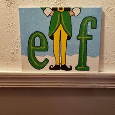 an elf painted on the side of a wall next to a sign that says elf