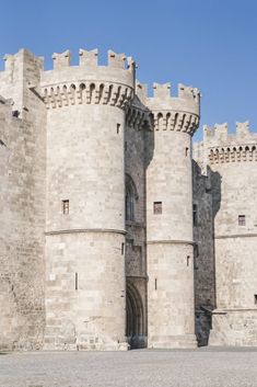 an old stone castle with two horses standing in front