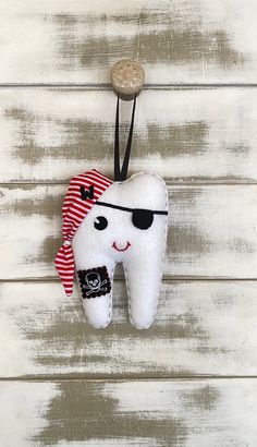 a tooth with sunglasses and a pirate hat hanging on a wall