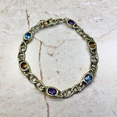 CLEARANCE - 40% OFF! Vintage 14 karat yellow gold multi gemstone link bracelet featuring 2 oval Amethysts, 2 oval Blue Topaz and 2 oval Citrines weighing approximately 2.5 CTTW. Each stone measures approximately 5.5 x 4.30 mm. L: 7 1/4 Inches / 18.41 cm. W: 6.57 mm. The bracelet weighs 11 grams. Birthstone: February/November/December. Condition: Very Good. Light scratches throughout metal. - Free insured shipping in the US. - International shipping available. Note: This item has been appraised a Yellow Gold Multi-stone Oval Bracelet, Yellow Gold Multi-stone Oval Bracelets, Yellow Gold Oval Multi-stone Bracelet, Yellow Gold Oval Bracelet With Multi-stone, Edwardian Style Engagement Ring, Smoky Quartz Jewelry, Gemstone Rings Vintage, Topaz Bracelet, December Birthstone Jewelry