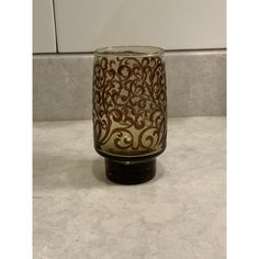 a glass vase sitting on top of a counter next to a tiled wall and floor