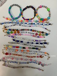 several bracelets are arranged together on a white surface with the word love spelled in small letters