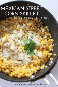 corn and feta in a skillet with a green garnish on top