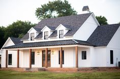 a white house with black shingles on the roof