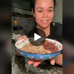 a woman holding a bowl full of food