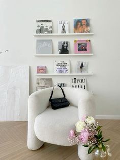 a white chair sitting in front of a wall filled with books