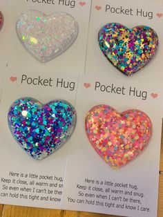 four heart shaped brooches are shown in three different colors and sizes, with the words pocket hug written below them