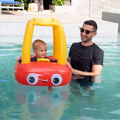 a man and his son are in the pool with an inflatable toy boat