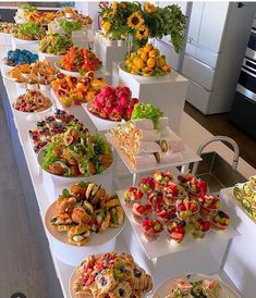 a buffet table filled with lots of different types of food on plates and trays