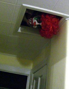 a red clown wig hanging from the side of a door way above a doorway with an open window