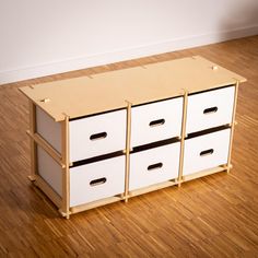 three drawers are stacked on top of each other in front of a white wall and wooden floor