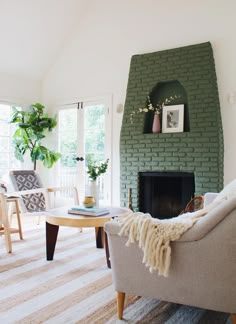 a living room filled with furniture and a fire place in front of a brick wall