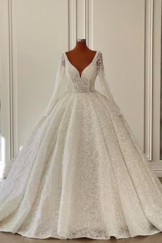 a wedding dress on display in front of a white wall