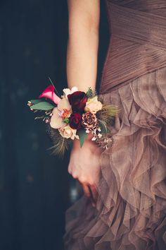 a woman in a brown dress holding a bouquet of flowers on her wrist with the caption pinterest