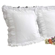 two white pillows with ruffled edges and one filled with chocolate candies next to each other