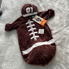 a baby's football outfit laying on top of a bed