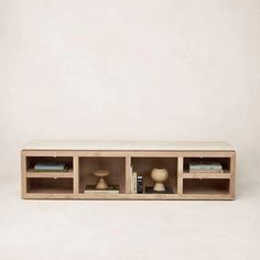 a wooden shelf with books, vases and other items in it on a white background