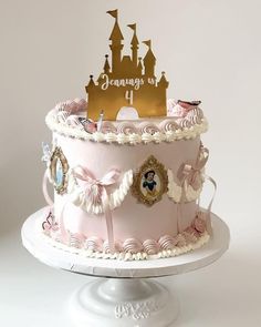 a pink cake with white frosting and gold decorations