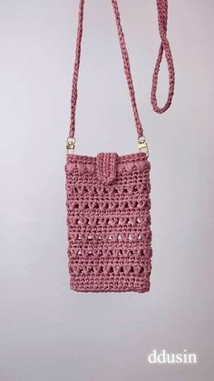 a pink crocheted purse hanging from a hook