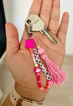 a hand holding a keychain with some beads and charms attached to it's wrist